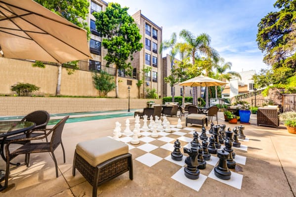Outdoor chess area with seating and building in background