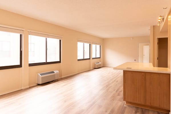 Spacious living area with large windows and wooden flooring
