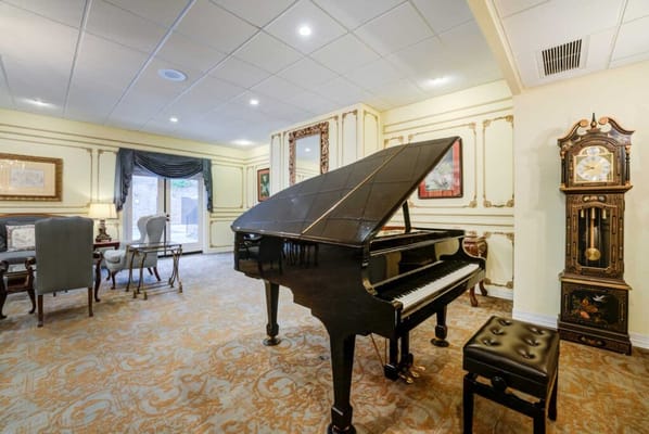 Interior lounge area with a black piano and clock