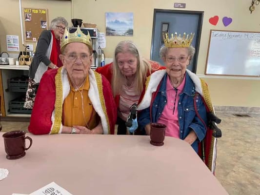 Residents celebrating in a common area dressed as royalty
