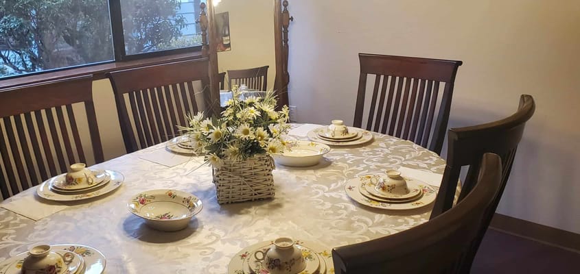 Dining table set with floral dishes and silverware