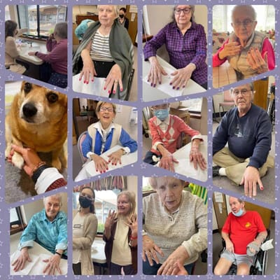 Residents in an activity room showing off their manicures