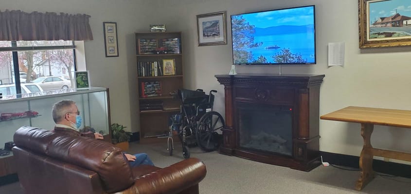 Resident watching TV in a cozy lounge area