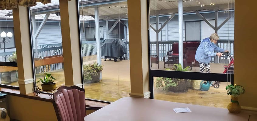 Resident using a walker in a common area with garden view