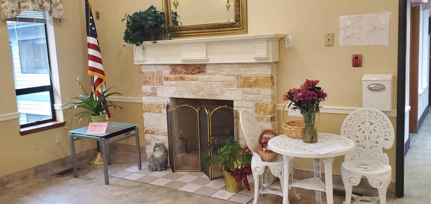 Cozy common area with seating, plants, and a fireplace