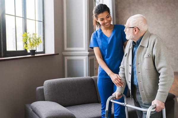 Staff assisting a resident in a cozy interior setting