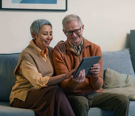 A couple enjoying a tablet together on a couch
