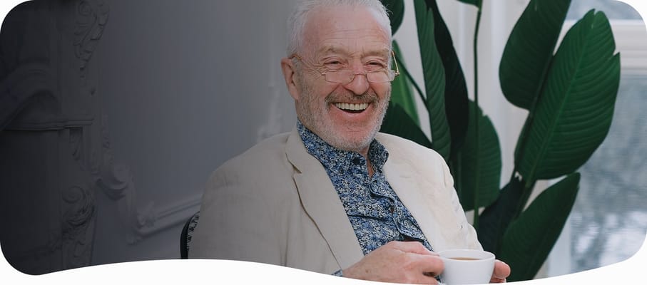 Resident enjoying a cup of coffee in an indoor setting