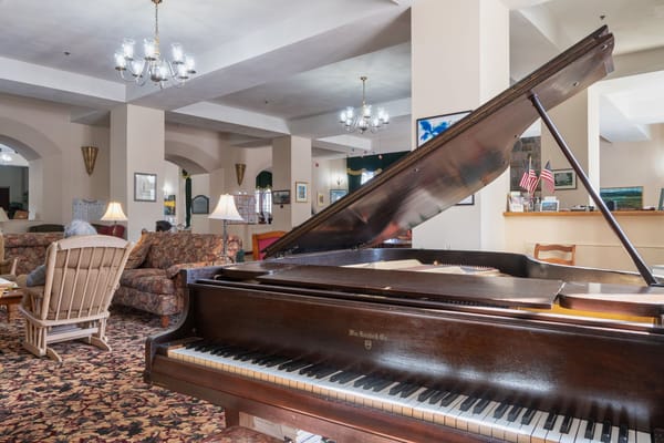 Common area with a piano, sofas, and decor