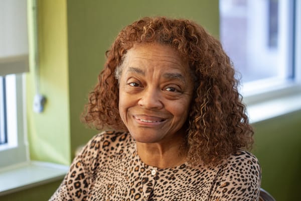 Smiling resident with curly hair in a cozy interior setting