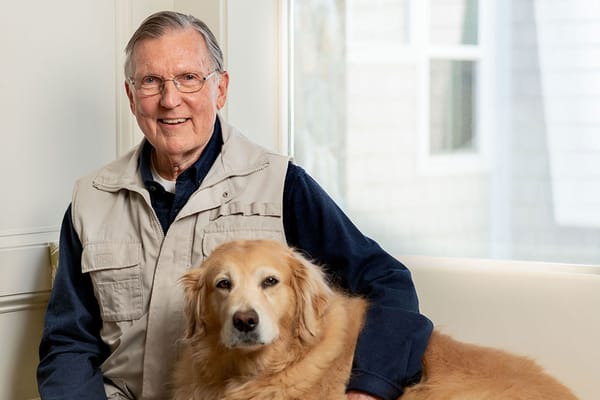 Senior man and golden retriever in a cozy sitting area