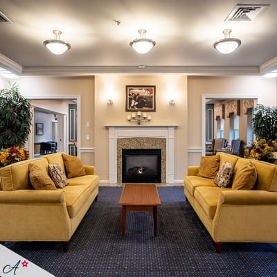 Cozy common area with yellow sofas and a fireplace