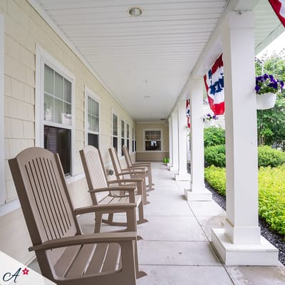 Wooden rocking chairs lined on a covered patio