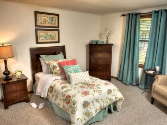 Cozy resident room with decorative bedding and furniture
