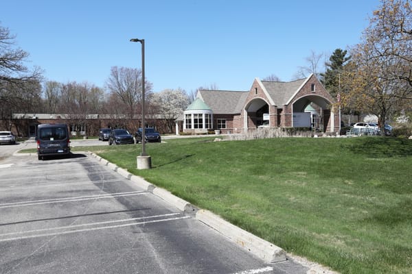 Building exterior of Manoogian Manor with parking area