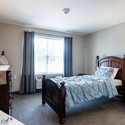 Bright, furnished resident room with bed and window