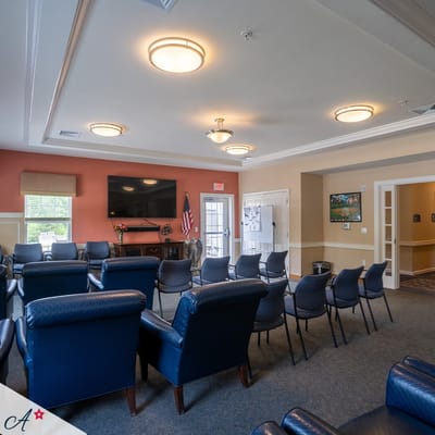 Common area with seating and TV in assisted living facility