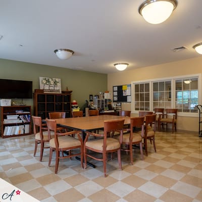 Bright common area with tables and chairs for activities
