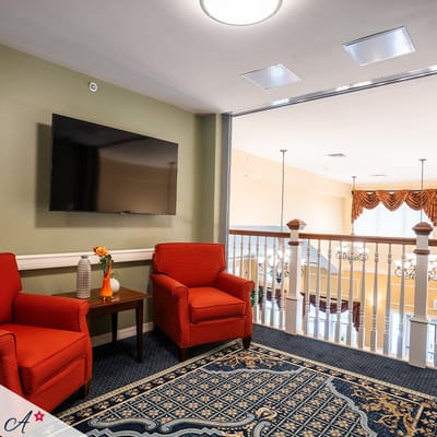 View of a cozy lounge area with chairs and a TV