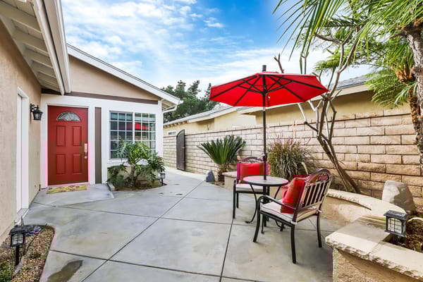 Outdoor patio area with red umbrella and plants