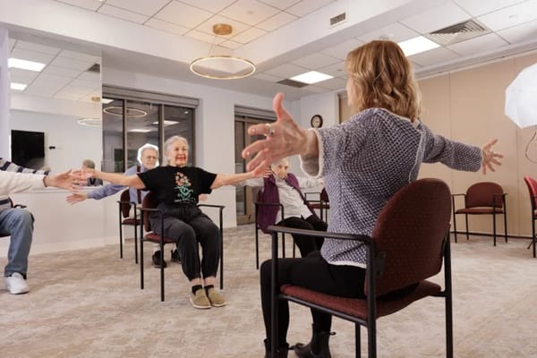 Residents participating in a seated exercise class