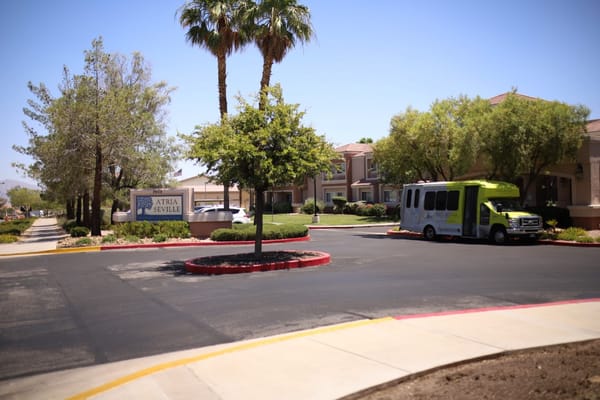 Exterior view of Atria Seville with greenery and transport van