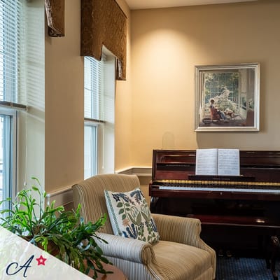 Cozy corner of a common area with a piano and seating