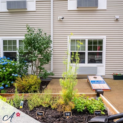 Garden with herbs and yard games at a senior living facility