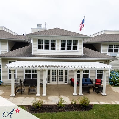 Exterior view of the facility with outdoor seating area and flag