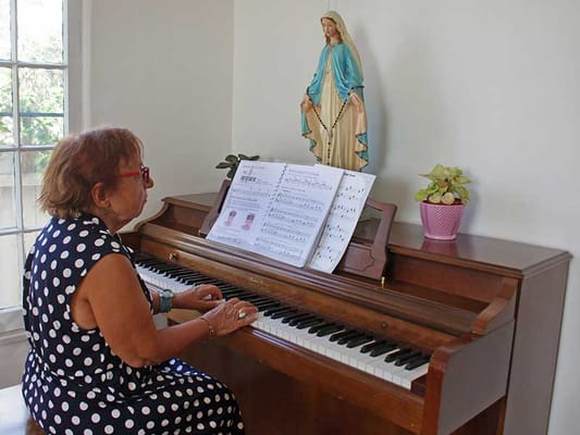 Resident playing piano in an interior space