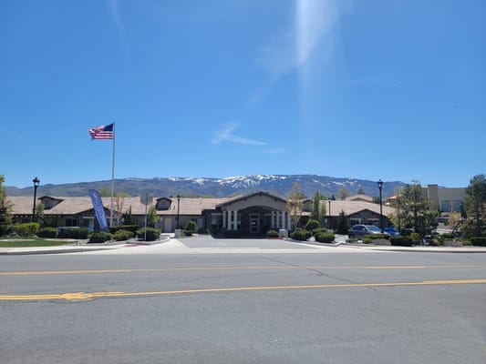 Sunny entrance of Stone Valley Memory Care with mountains in the background
