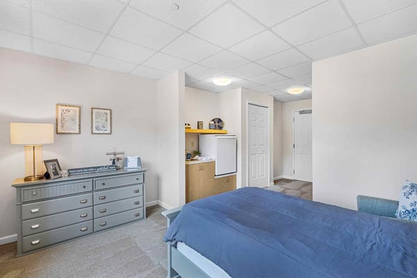 A private room with a bed and dresser in a senior living facility