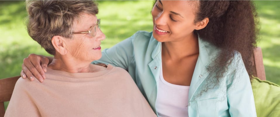 Staff member with a resident in a garden setting
