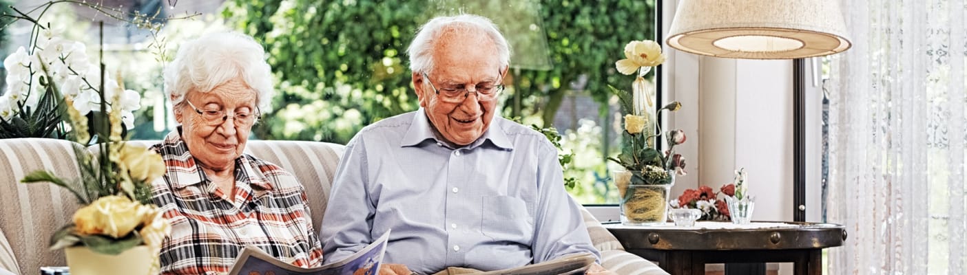 Senior couple reading together in a bright lounge area