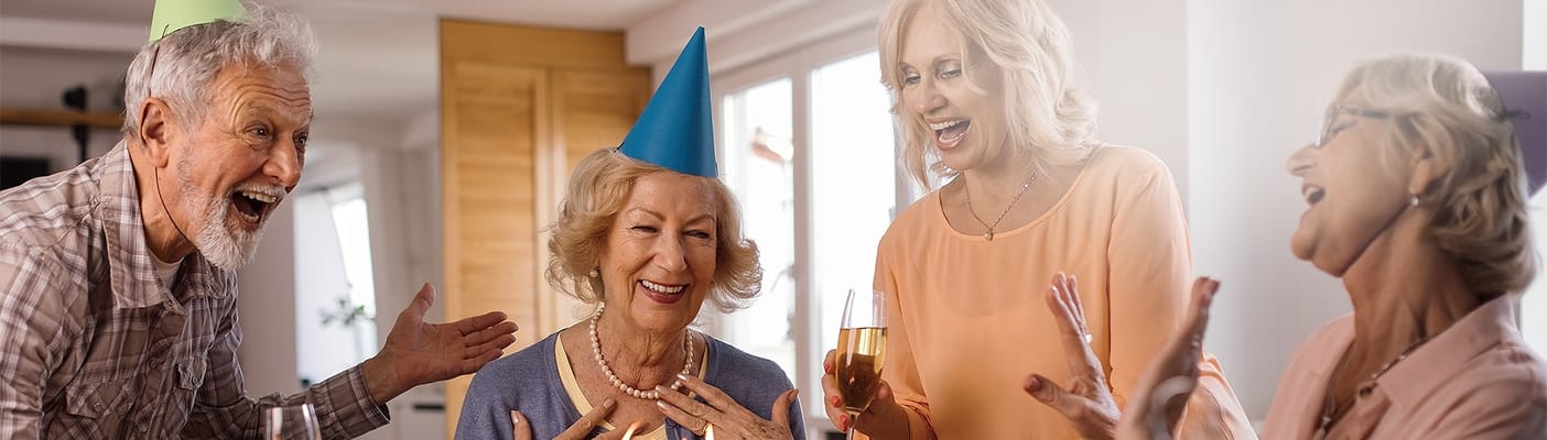 Residents celebrating with party hats and drinks