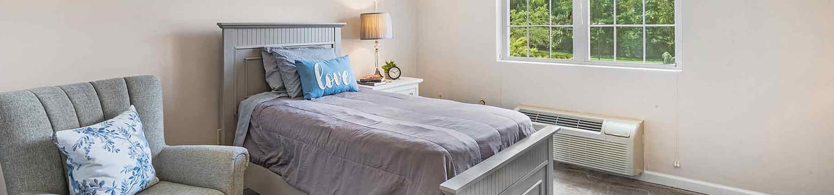 A well-furnished resident room with a bed and window
