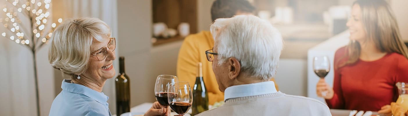 Residents enjoying a meal and toasting at a dining table