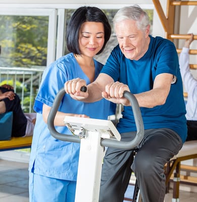 Staff assisting a resident with exercise equipment