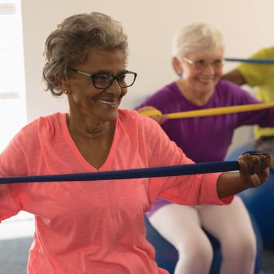 Residents exercising in a vibrant activity room