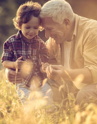 A senior man enjoying time with a young boy in a field