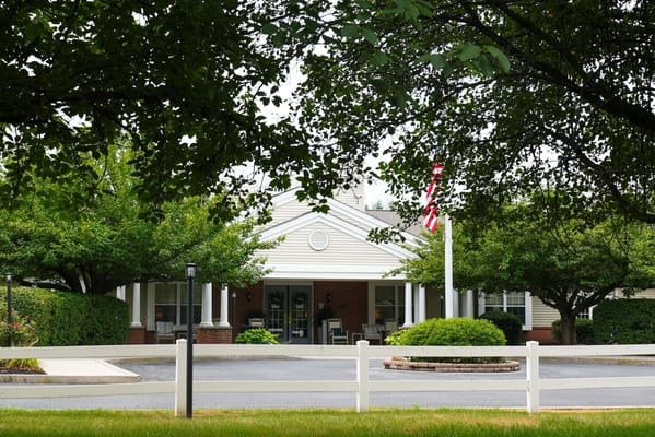 Exterior view of the facility with trees and flag