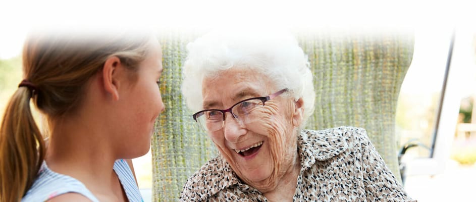 Elderly woman joyfully interacting with a young girl