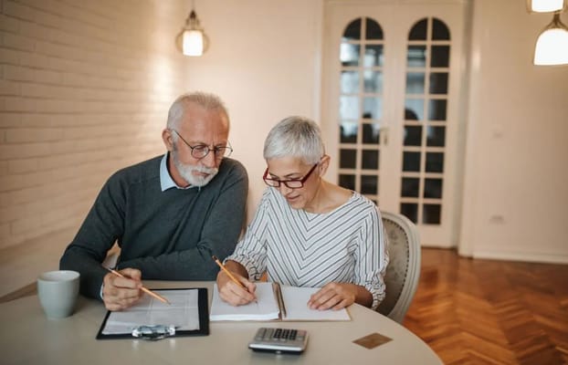 Two seniors engaged in a discussion at a table