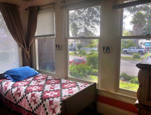 A cozy resident room with a bed and window view