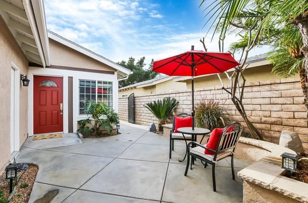 Outdoor seating area with red umbrella and plants