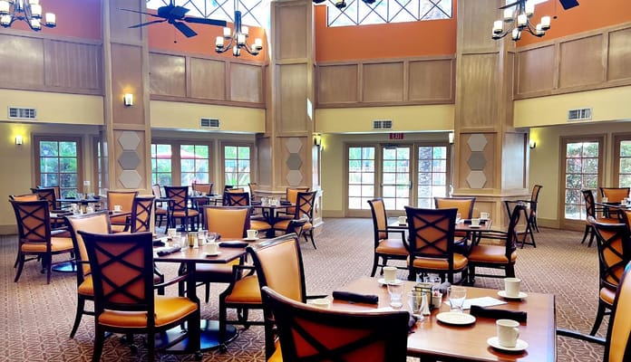 Bright dining room with tables and chairs set for meals