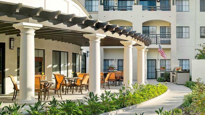 Outdoor seating area with plants and building in the background