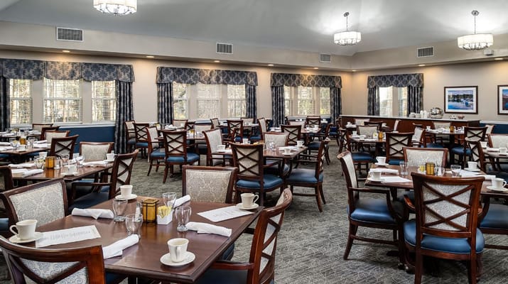 Dining room filled with tables and chairs for residents