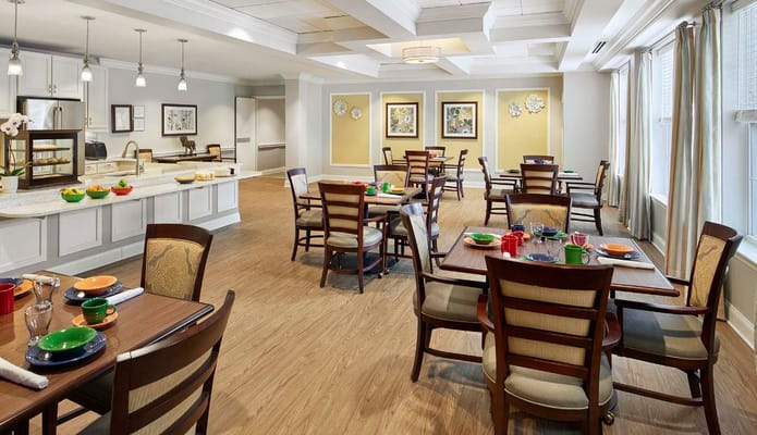 A spacious dining room with wooden tables and chairs set for meals.