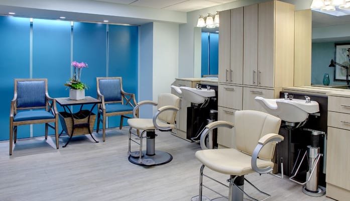 Bright salon area with styling chairs and floral decoration